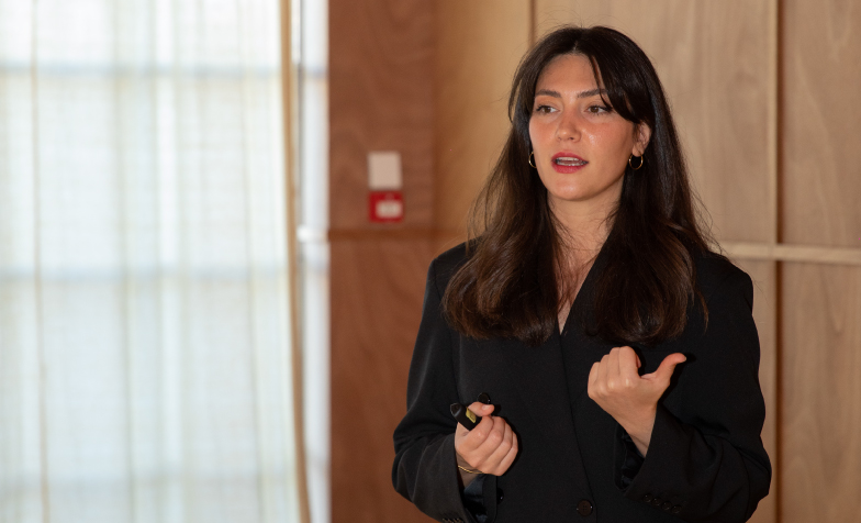 A person in a black suit 
Description automatically generated