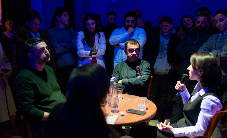 A group of people sitting around a round table
Description automatically generated