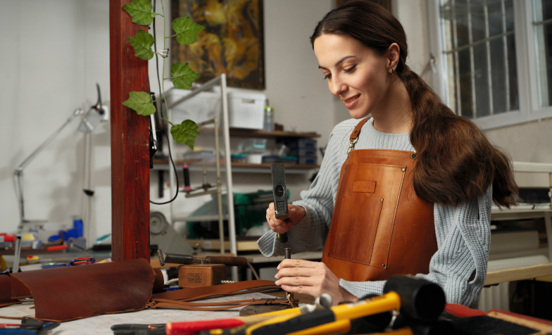 A person working on a leather piece
Description automatically generated
