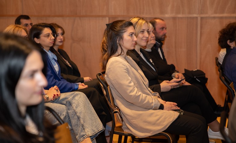 A group of people sitting in chairs 
Description automatically generated