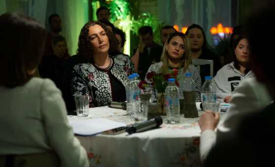 A group of people sitting at a table
Description automatically generated